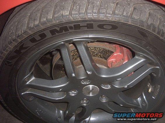 Close-up of a car wheel with Kumho tire and red brake caliper
